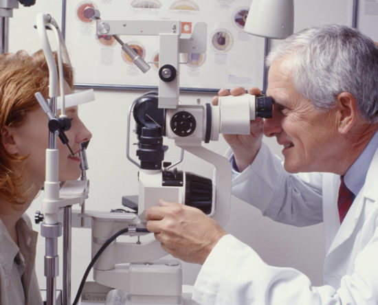 optometrist with patient, giving an eye examination