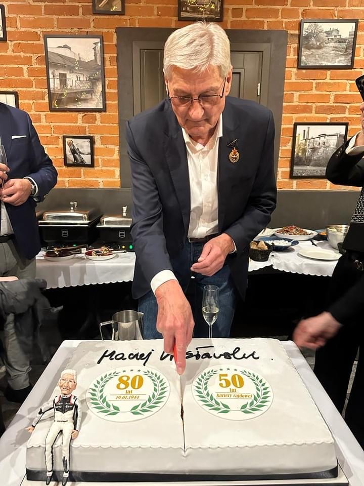 Maciek Wisławski krojący tort jubileuszowy