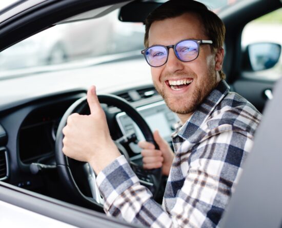 Człowiek w samochodzie z uniesionym kciukiem