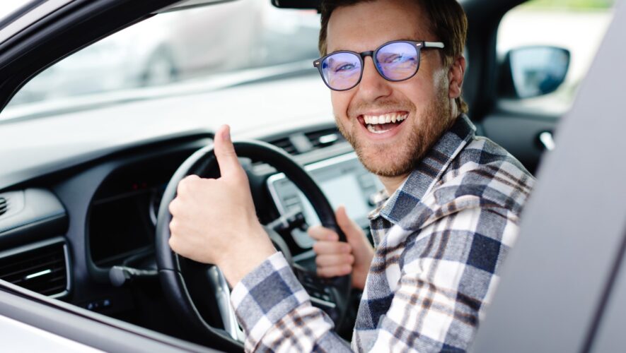 Człowiek w samochodzie z uniesionym kciukiem
