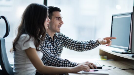 dwie osoby przed komputerem