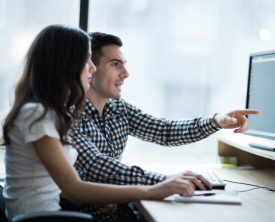 dwie osoby przed komputerem